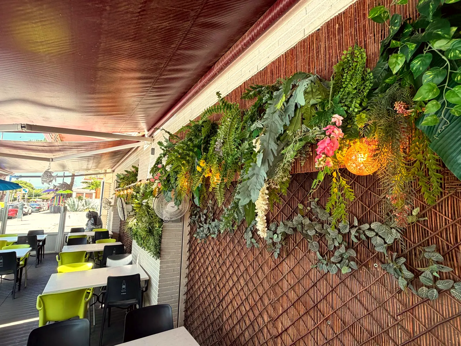 Terraza del restaurante en Blanes con pared vegetal y luces cálidas